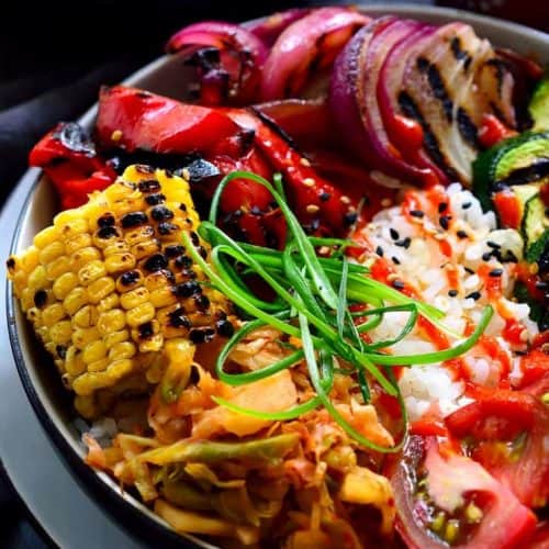 This vegan bibimbap features fresh grilled summer vegetables, kimchi and crispy-bottomed rice (no special equipment required). A tasty bowl of rainbow goodness, this bibimbap recipe can be adapted to use whatever vegetables you have on hand!