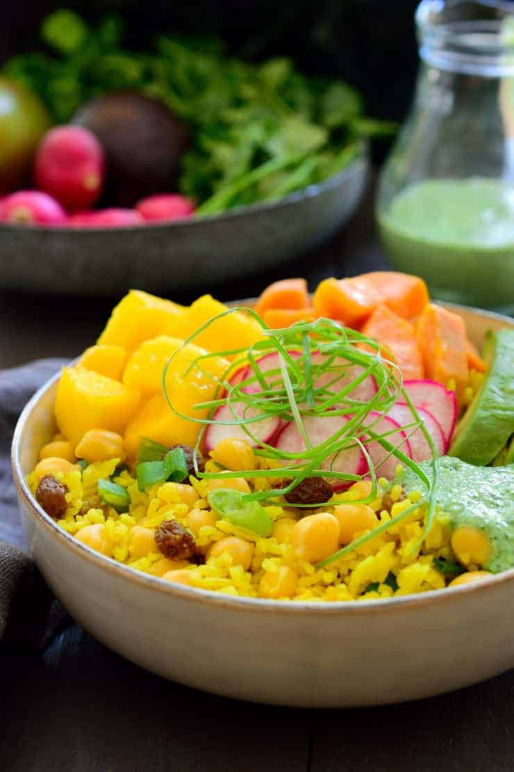 This vegan Buddha bowl is built on a base of fragrant curried rice and chickpeas and topped off with coconut-glazed sweet potato, fresh juicy mango, creamy avocado and a simple cilantro dressing. This curried rice vegan Buddha bowl is an explosion of flavours, simple to put together and a great make-ahead meal prep recipe.