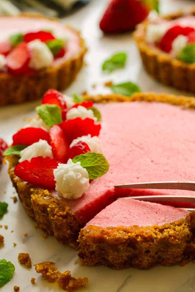 Vegan strawberry mousse tart with a fork taking a slice.