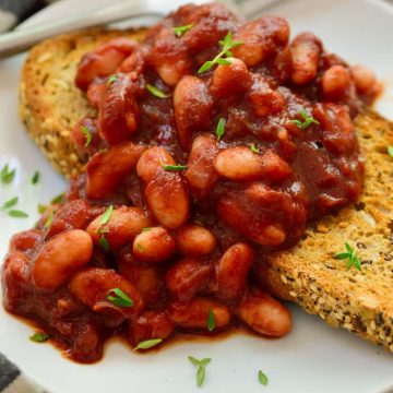 Smoky vegan beans on toast served on a plate.
