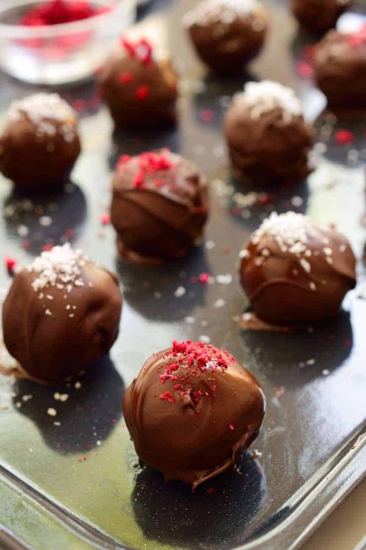 Chocolate-covered raspberry bounty balls on a tray.