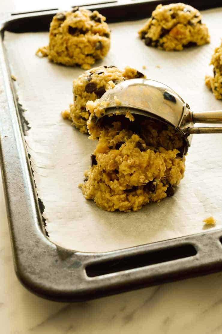 Scooping the cookie dough onto a pan with an ice cream scoop.