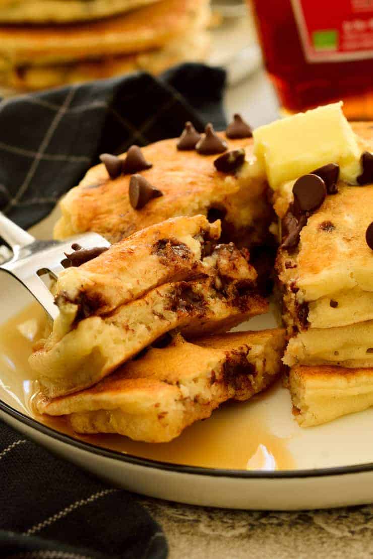 Sliced vegan chocolate chip pancakes on a plate.