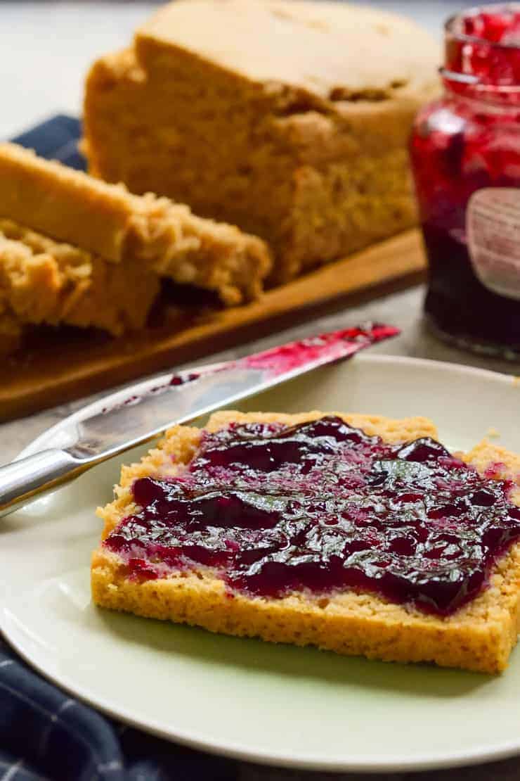 A slice of peanut butter bread with jam on it on a plate.