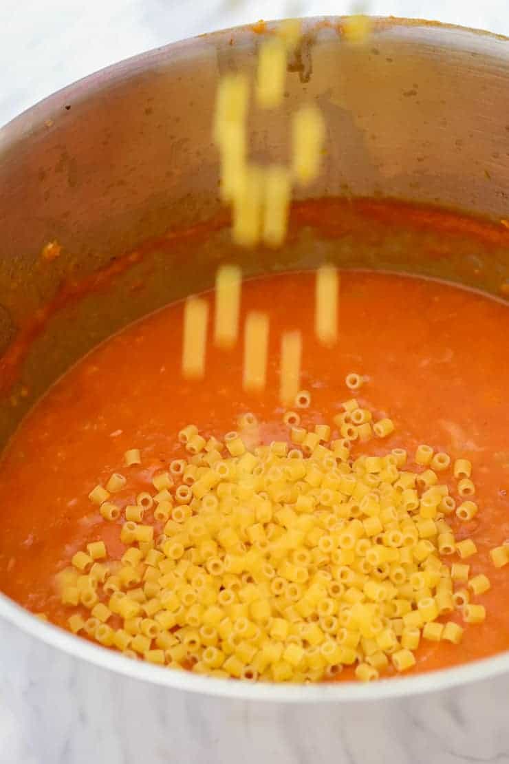 Pouring the pasta into the pot.