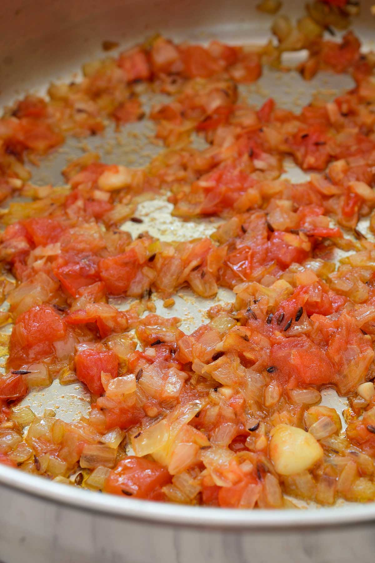 Inside the pan on fried tomatoes, onion and spices.