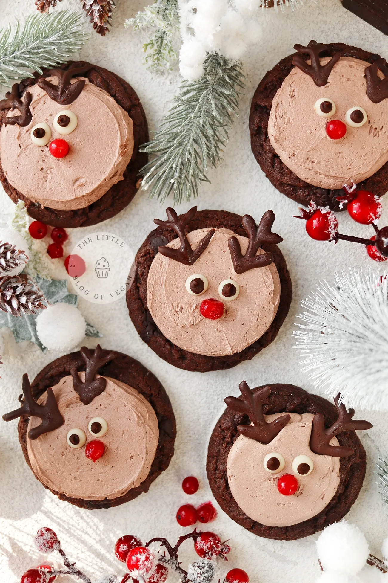 Reindeer face-shaped chocolate cookies with red noses.