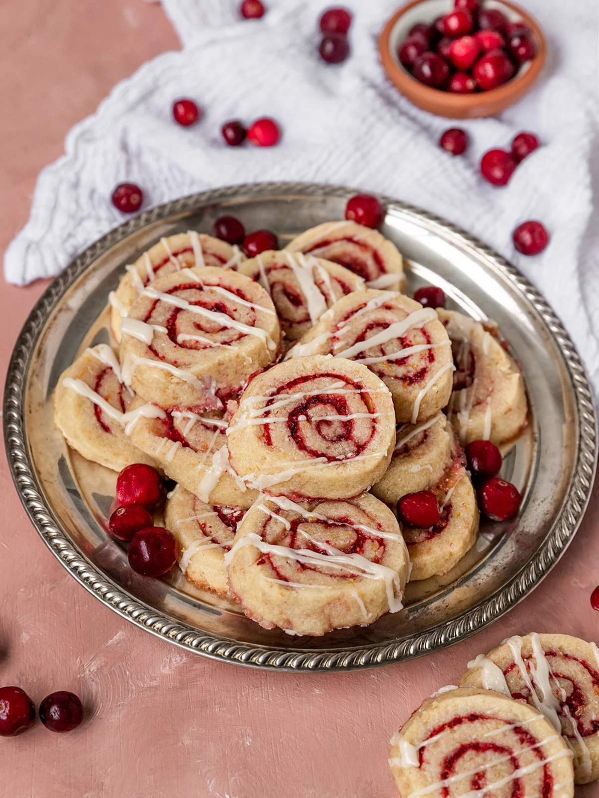 A metal plate with a pile of cranberry pinwheel cookies.