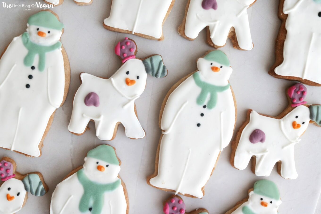 White and pastel-coloured cookies in the shape of a snowman and dogs.