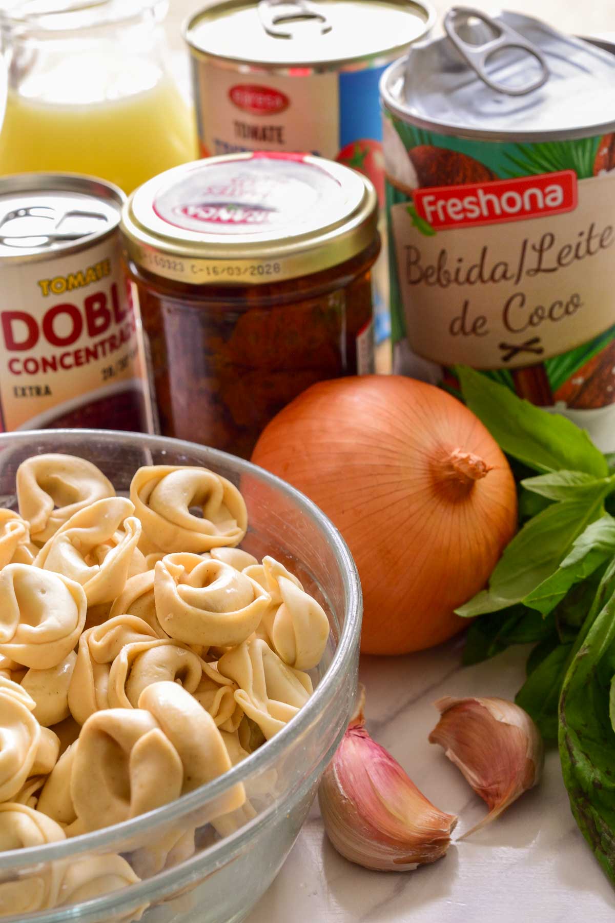 The ingredients for vegan tortellini soup on a counter.