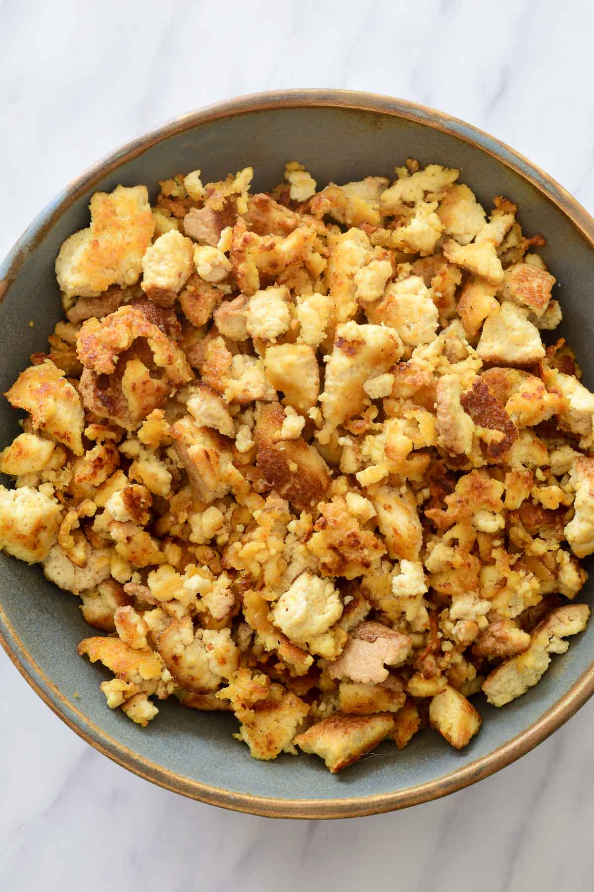 A blue-grey bowl filled with fried smoked tofu crumbles.
