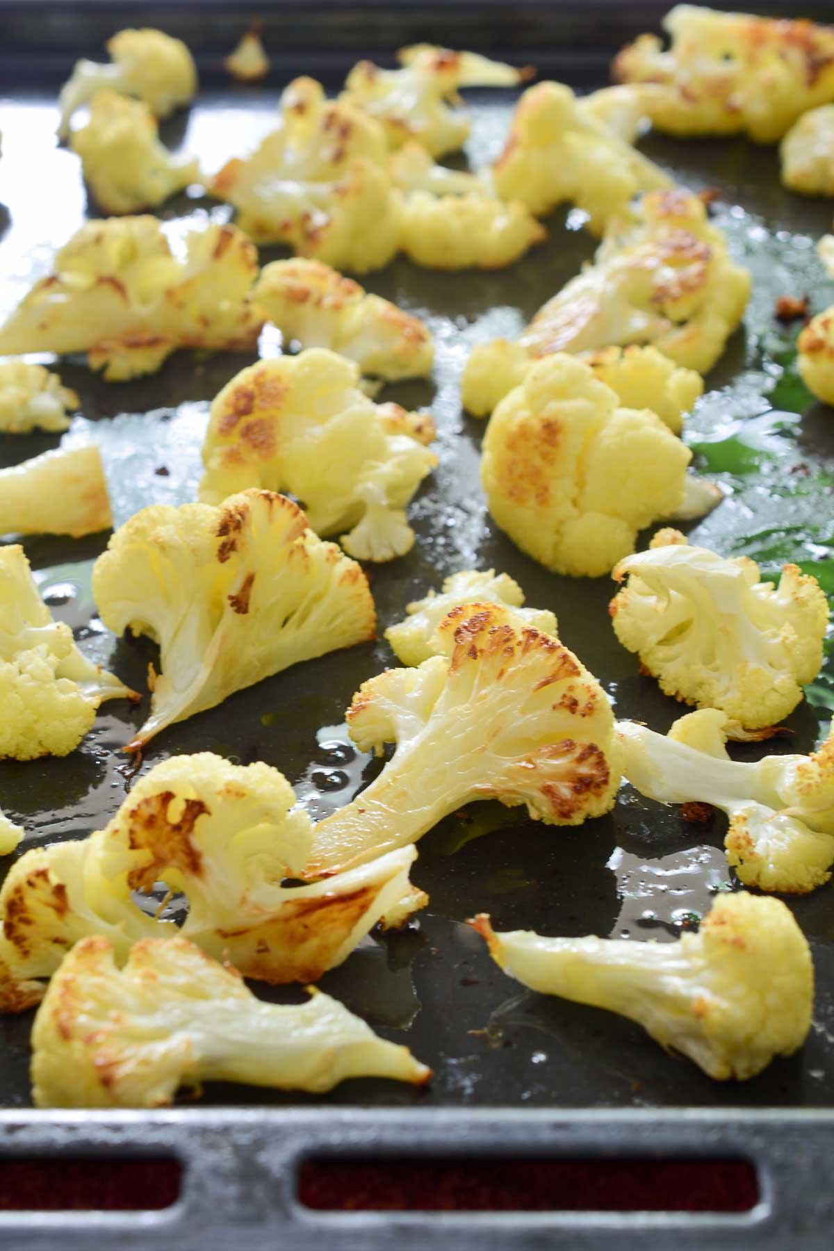 A black pan of roasted cauliflower florets.